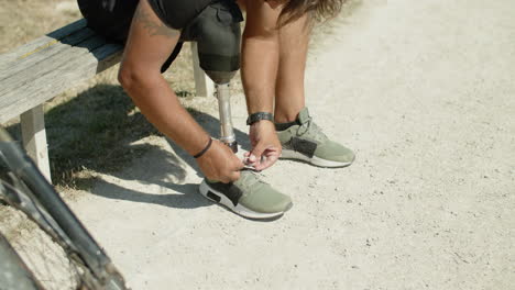 Slow-motion-of-man-with-prosthetic-leg-tying-laces-on-sneakers
